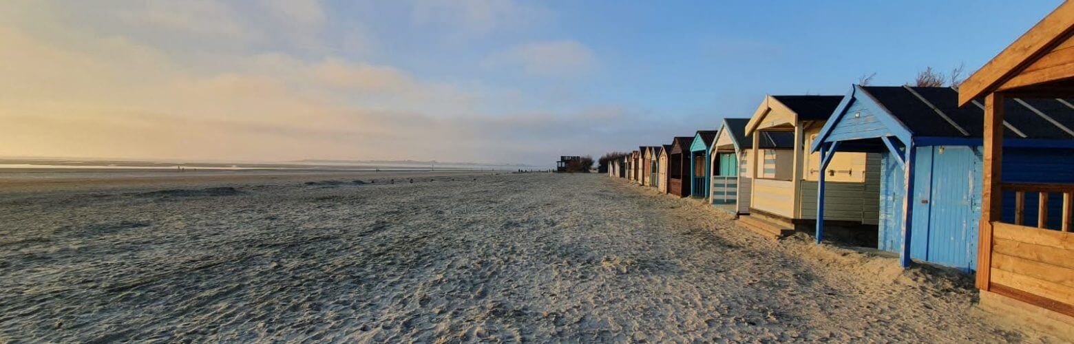 a row of beach huts at sunset